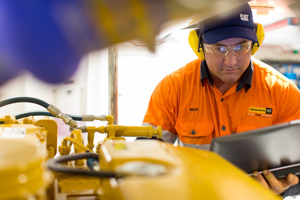 CAT technician inspecting marine engine